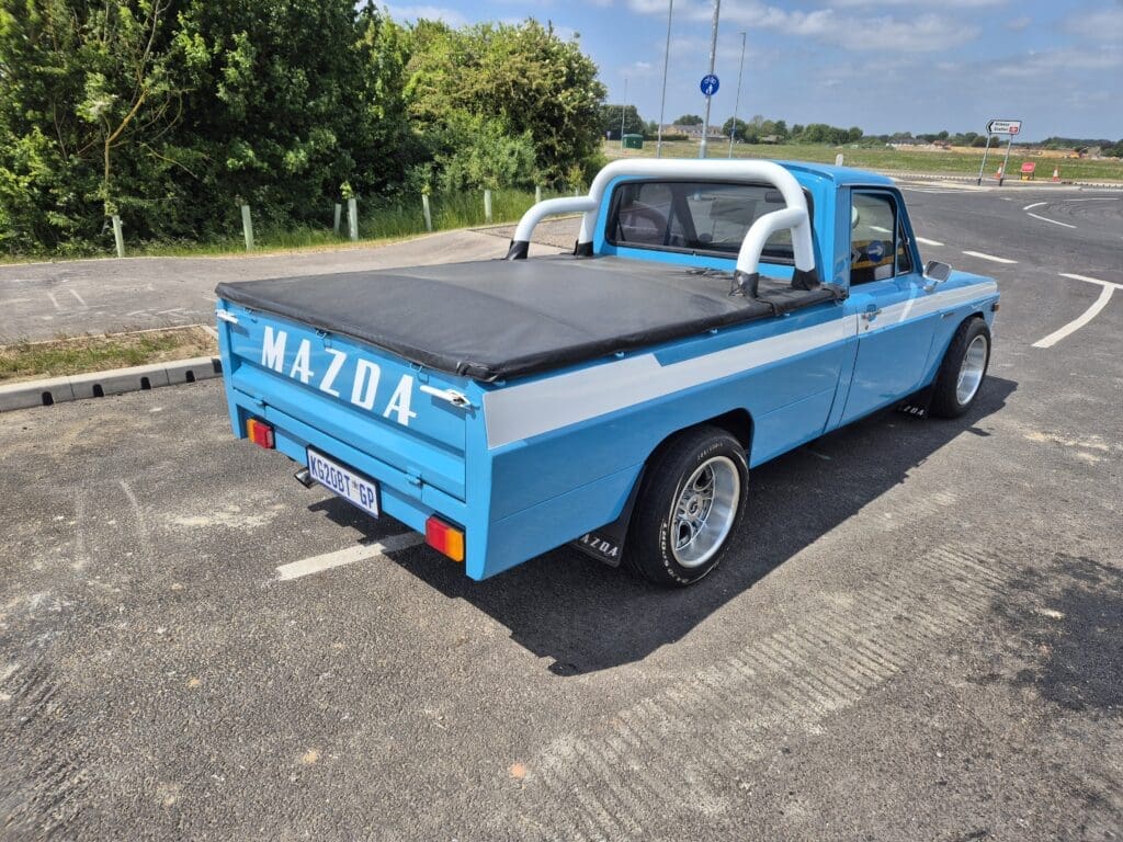 Classic blue Mazda pickup truck parked outdoors on a sunny day.