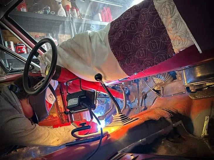 Car interior with welding process visible.